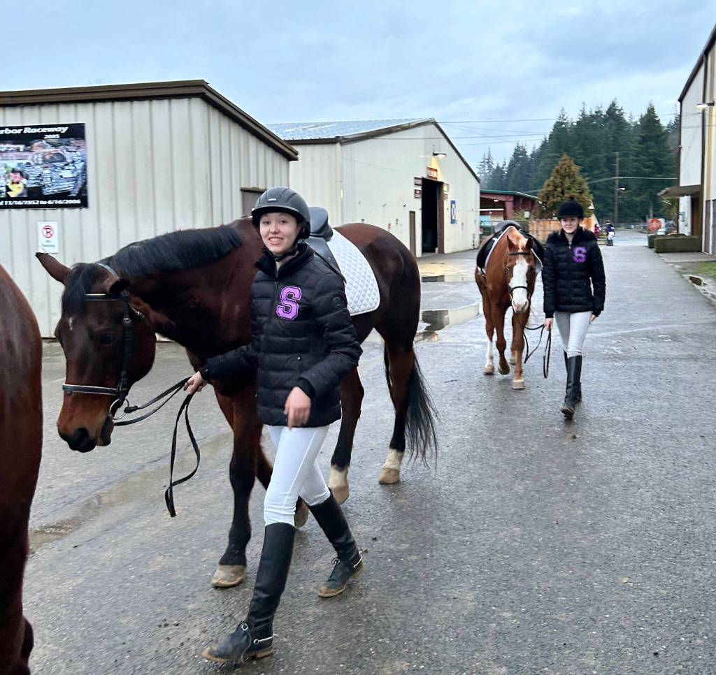 Katelynn Sharpe and Celbie Karjalainen prepare for the dressage competition at the first district meet of the season in Elma in late January.