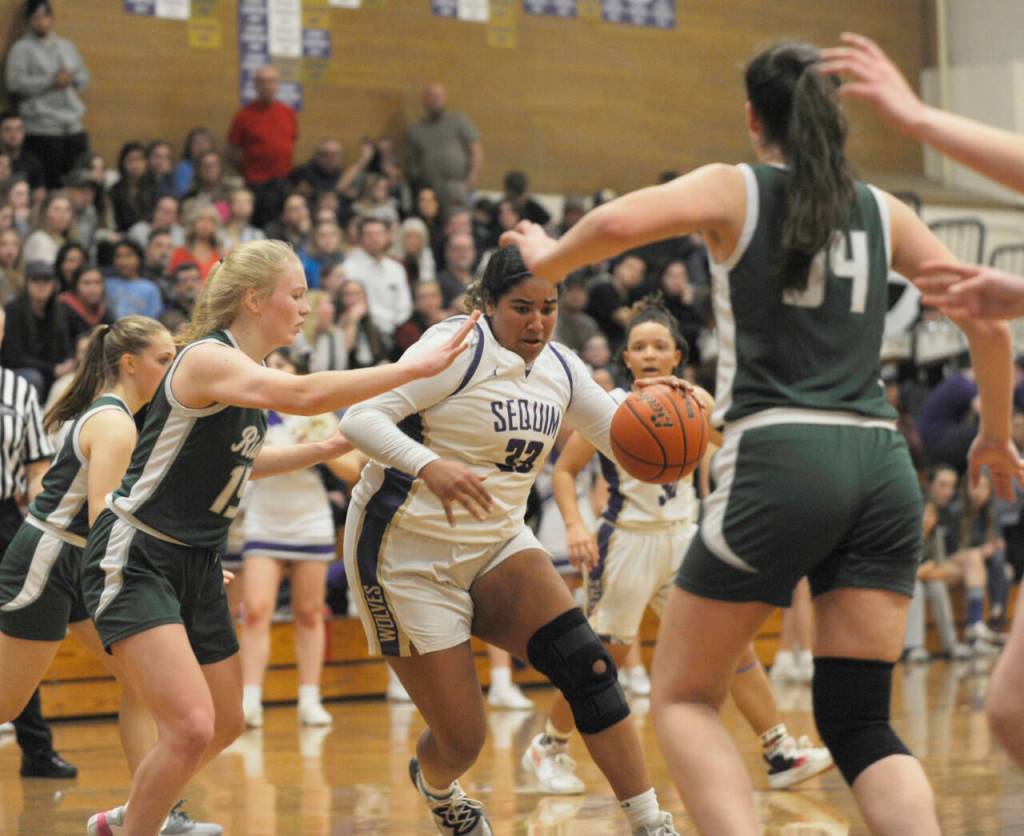 Sequim Gazette photo by Michael Dashiell / Sequim post Jelissa Julmist, center, muscles through the Port Angeles defense for two of her team-high 18 points in a 57-46 SHS win on Feb. 2, to cap an undefeated league record (14-0). Defending the play are Port Angeles Paige Mason, left, and Lexie Smith.