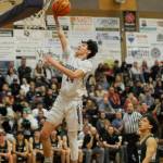 Sequim Gazette photo by Michael Dashiell / Sequim guard Vince Carrizosa, left, slams home a basket in the Wolves 60-57 win over rival Port Angeles on Feb. 2 in Sequim. Port Angeles Kason Albaugh looks on.