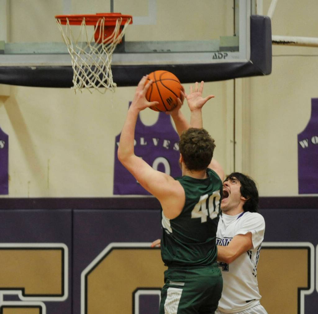 Sequim Gazette photo by Michael Dashiell / Sequims Cole Smithson, right, tries to defend the basket as Port Angeles Isaiah Shamp looks to score in the first half of the Wolves Olympic League win on Feb. 2.