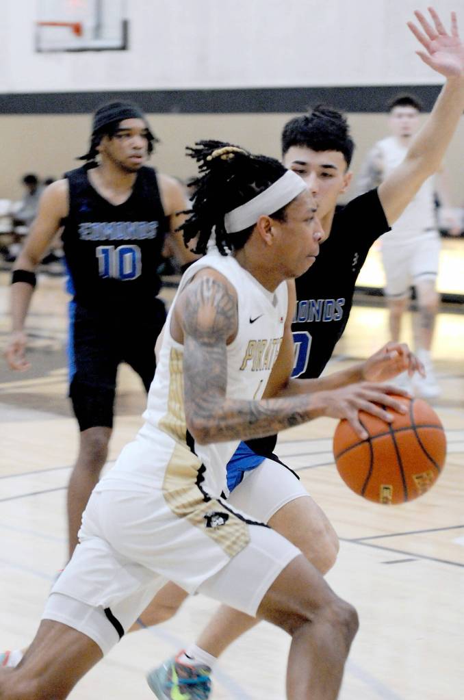 Photo by Keith Thorpe/Olympic Peninsula News Group / Peninsulas Mikey Medlock Jr., front, heads for the lane against Everetts Leon Sayers on Jan. 28 in Port Angeles.