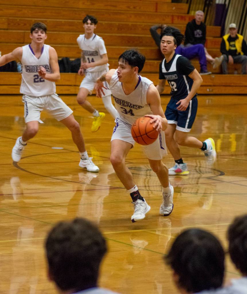 Sequim Gazette photo by Emily Matthiessen / Sequims Isaiah Moore, center, looks to push the ball upcourt as teammates Brett Mote (22) and Vince Carrizosa (14) follow the play, in a West Central District game against Lindbergh on Feb. 15.