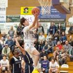 Sequim Gazette photo by Emily Matthiessen / Sequims Vince Carrizosa, center, drives past Lindberghs Gabriel Thomas (1) for a score in the Wolves 66-37 West Central District tournament playoff win on Feb. 15.