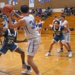 Sequim Gazette photo by Emily Matthiessen / Sequims Isaiah Moore (34) looks to pass to teammate Espn Judd as Lindberghs John Chuol (22) and Justin Tu (12) defend in a Feb. 15 West Central District tournament game in Sequim. The Wolves topped Lindbergh, 66-37.