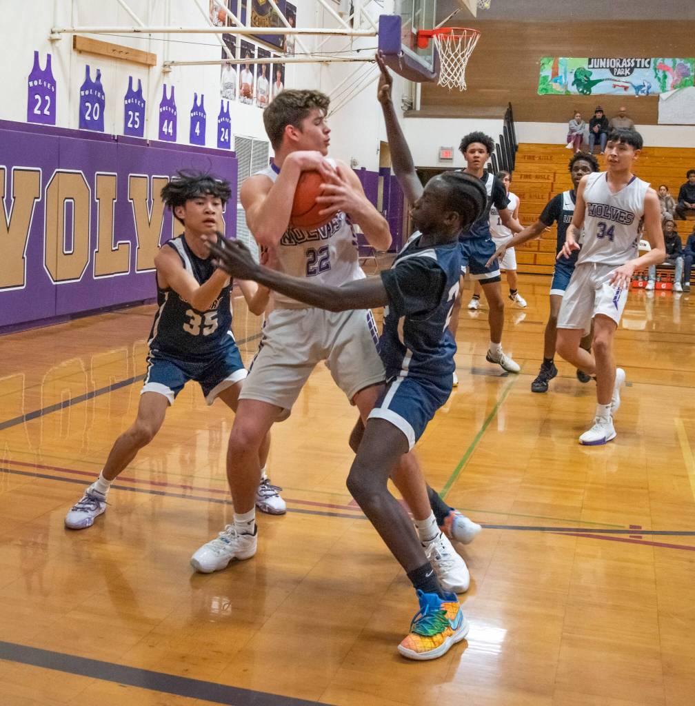 Sequim Gazette photo by Emily Matthiessen / Sequims Brett Mote, center, looks to pass as hes pressured by Lindberghs Dylan Villez, left, and John Chuol in a Feb. 15 West Central District tournament game.