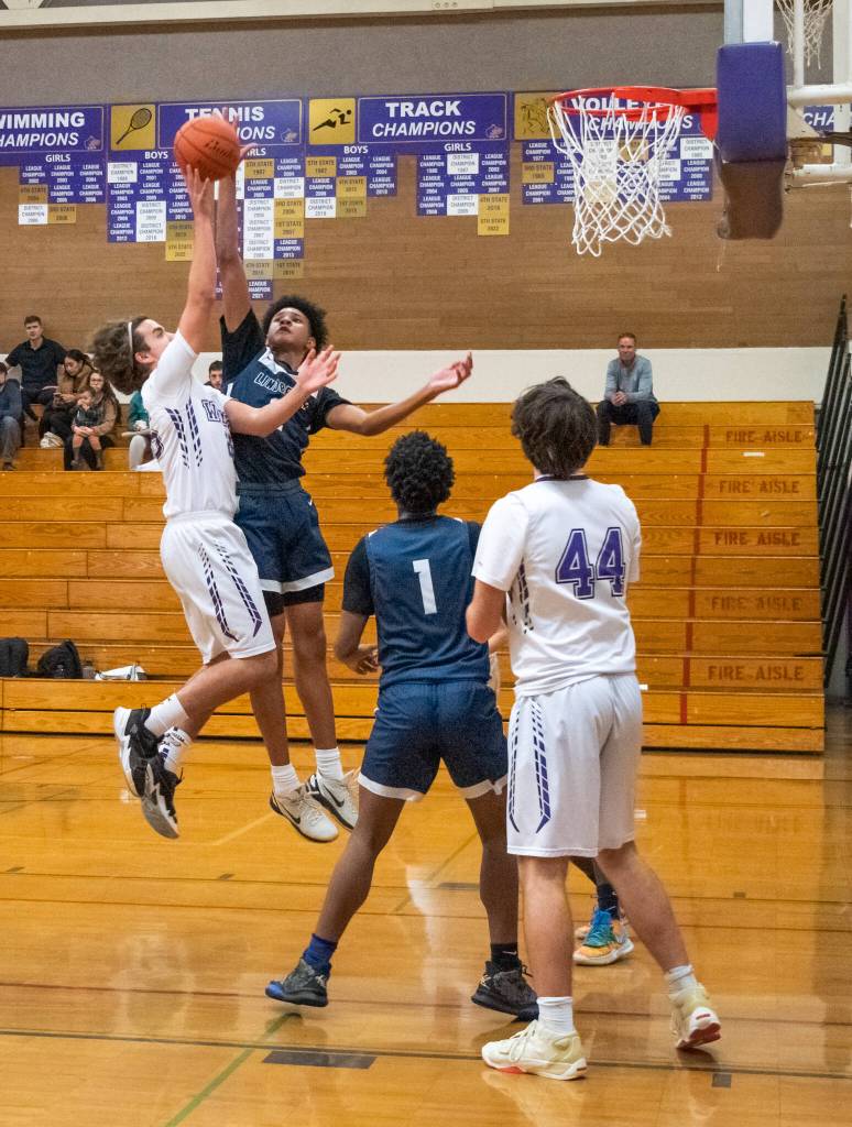 Sequim Gazette photo by Emily Matthiessen / Lindberghs James Huff looks to block a shot by Sequims Lars Wiker in Sequims 66-37 West Central District playoff win on Feb. 15. Looking on are Sequims Cole Smithson, right, and Lindberghs Gabriel Thomas.
