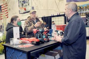 Jack and Marcella Ridge of Sequim talk about power tools with Tony Contestable, tool specialist with Hartnagel Building Supply of Port Angeles, right, during Saturday's 2023 Building, Remodeling & Energy Expo in the Sequim High School gym. The two-day event, hosted by the North Peninsula Building Association, featured a variety of booths, displays and presentations dedicated to home building, repair and remodeling. (Keith Thorpe/Peninsula Daily News)