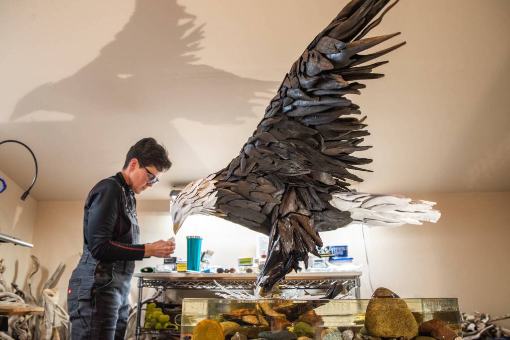 Sequim Gazette photo by Emily Matthiessen
Local driftwood artist Molly Omann puts some of the finishing touches on her latest effort, Fisher King  a 57-inch-tall bald eagle that she calls her most challenging piece.