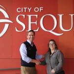 Photo courtesy of City of Sequim / Sequim City Manager Matthew Huish accepts a sponsorship from Nicole Hartman, Communications Manager and Public Records Officer for Clallam County PUD, to sponsor the Sequim Sunshine Festivals Interactive Light Experience at Pioneer Memorial Park.