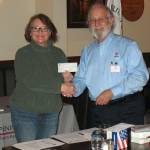 Submitted photo / Richard Havel (U.S. Navy, Ret.), president of the local Military Officers Association of America group, presents a $5,000 donation to Cheri Tinker, president of the North Olympic Peninsula Veterans Housing Network, at a luncheon in mid-February.