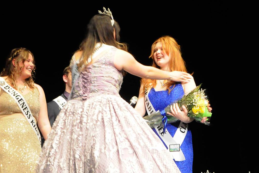 Sequim Gazette photo by Matthew Nash/ Princess Anne Marie Barni, right, learns shes awarded the Congeniality Award on Feb. 25, sponsored by Castell Insurance, for her kindness to fellow contestants during the pageant preparation process. Last years winner, queen Isabella Williams, presented her the award. This years Sequim Irrigation Festival royal court includes, from left, prince Fred Cameron, princess Anne Marie Barni, queen Pepper Reymond, and princess Paige Skylar Krzyworz. Theyll tour the region extensively this summer in parades representing Sequim as ambassadors.
