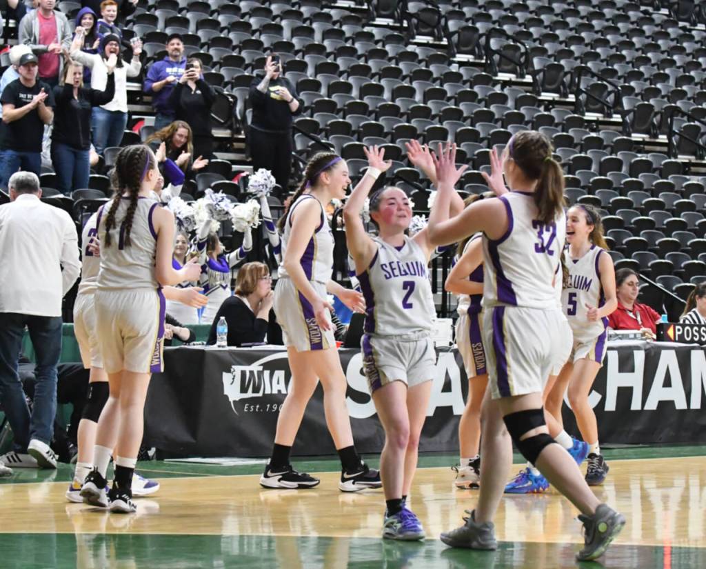 Photo by Jim Heintz / Sequims Hannah Bates (2) and Hailey Wagner (32) celebrate the Wolves Round of 12 victory at the class 2A state tournament in Yakima on March 1.