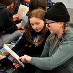 Sequim Gazette photo by Matthew Nash/ Charley Sturm, right, reads to Kennedy Larson, a third grader in Carolyn Luengens class, a book from the Geronimo Stilton series. Sequim High School classes walked to Helen Haller Elementary on March 2 to read with younger grades to celebrate Read Across America Day.