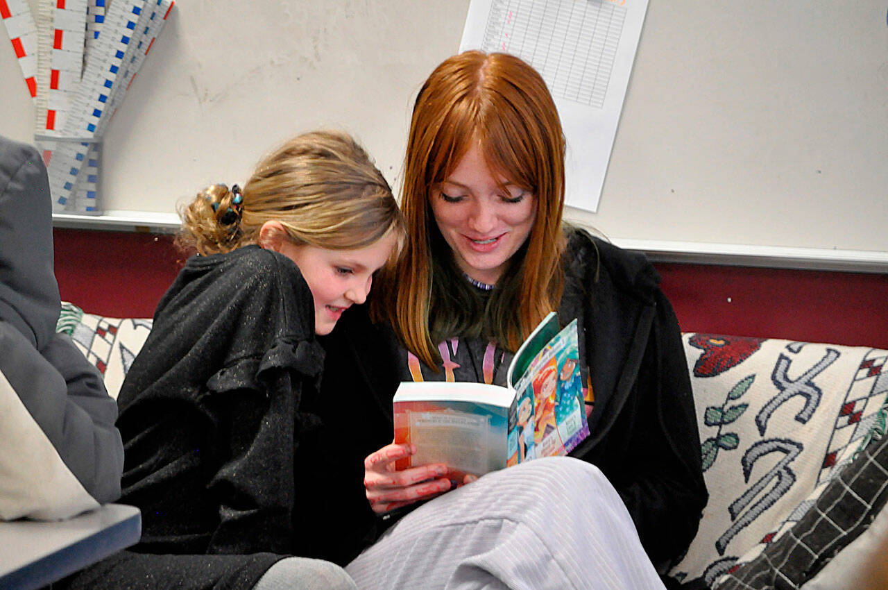 Sequim Gazette photo by Matthew Nash/ Eighth grader Chloe Pierson reads Star Darlings to third grader Rae-ann Wood in Shannon Greens classroom at Greywolf Elementary. Sequim Middle School sent eighth graders to read and work with kindergarten-third grade classrooms on March 2 for Read Across America Day.