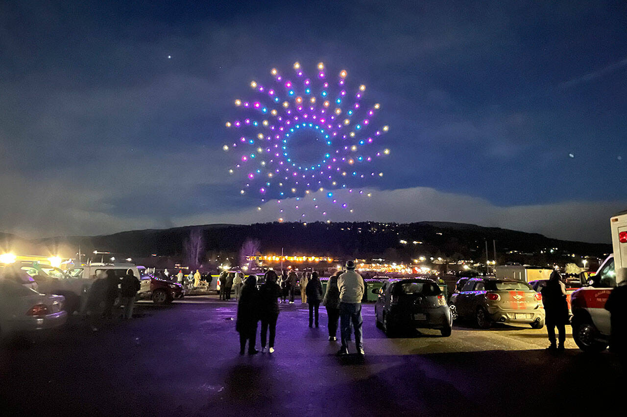Sequim Gazette photo by Matthew Nash/ A spiral made up of 200 drones flies above crowds in and near Carrie Blake Community Park for the Sequim Sunshine Festivals Illuminated Drone Show.