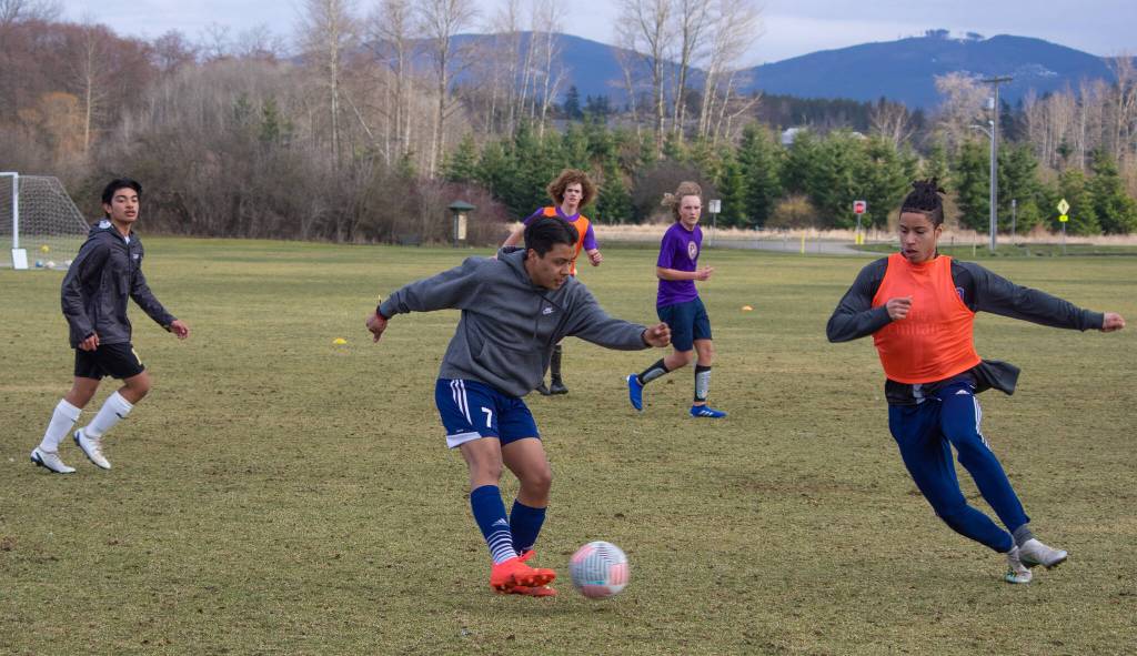 Sequim Gazette photo by Emily Matthiessen / Sequim High varsity soccer players practice in the Albert Haller Playfields last week. Abe Torres controls the ball as Mekhi Ashby comes in from his left.
