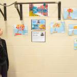 Sequim Gazette photo by Emily Matthiessen / Jayne Caulfield examines some of the artwork on display at Greywolfs Meet the Masters art class exhibition on Tuesday. These pieces were made by 4th and 5th grade children after studying the impressionism and landscapes of Monet.