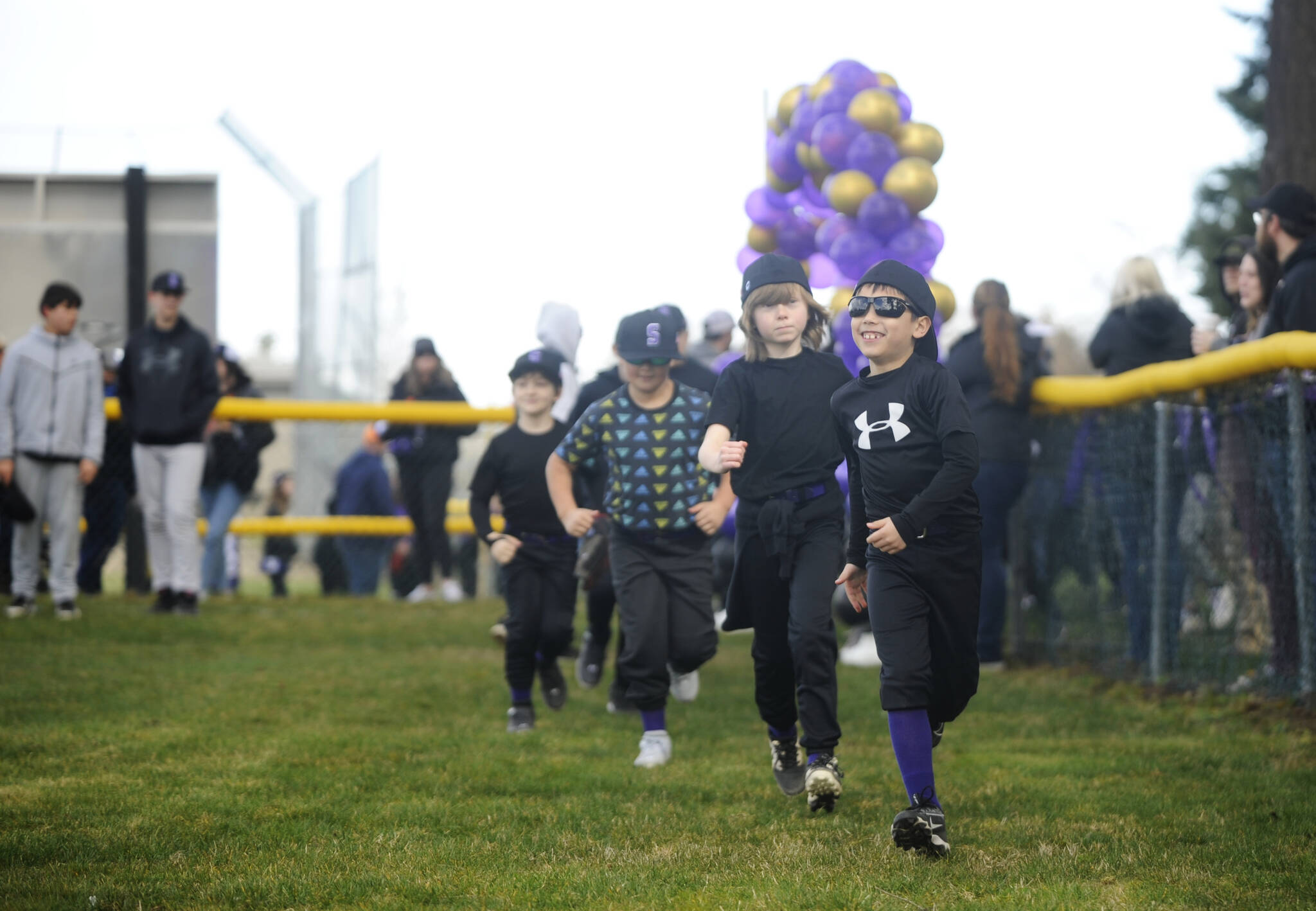 Sequim Gazette photoS by Michael Dashiell
Sequim Little Leaguers (from right) Brayden Smith, Aiden Fazio, Kayden Connelly, and Hudson Holgeson race onto the Don Knapp Field during the leagues parade of teams at the Opening Day ceremonies on April 25.