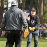 Volunteer Kris Lether, right, gets the ball back from Tony Knapp after throwing out the first pitch at the Sequim Little League Opening Day event on Saturday.