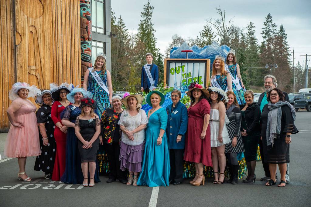 Sequim Gazette photo by Emily Matthiessen / Dignitaries, volunteers and dinner attendees pose for festival photographer Keith Ross with Princess Skylar Kryzworz, Prince Fred Cameron, Princess Anne Marie Barni and Queen Pepper Reymond as they try out their float for the first time at the kick-off dinner and auction for the Irrigation Festival at the 7 Cedars Resort on March 25.