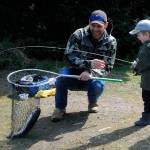 Sequim Gazette file photo by Matthew Nash / Craig Larson helps his 3-year-old son Barrett net a rainbow trout during Kids Fishing Day in April 2022. It was Barretts first catch ever, Larson said.