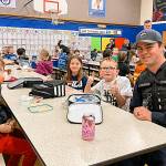 Photo courtesy Helen Haller PTO/ Sequim Schools resource officer Kyle Resser meets with second graders, from left, Tommy Hall, Ava Schoessler, and Kayden Simpson from Mrs. Mullikins class at a Law Enforcement Appreciation Lunch on March 27 in Helen Haller Elementary.