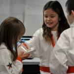 Sequim Gazette photo by Matthew Nash/ Nai Gish, center, examines Bekah Abkens egg drop device during a soft landing exercise.