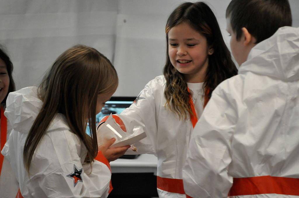 Sequim Gazette photo by Matthew Nash/ Nai Gish, center, examines Bekah Abkens egg drop device during a soft landing exercise.