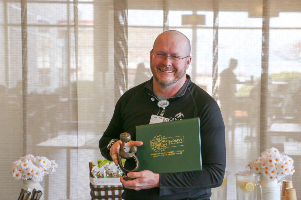 Photo courtesy of Olympic Medical Center
Registered nurse John Petrisin-Connelly accepts his Daisy Award for Extraordinary Nurses.