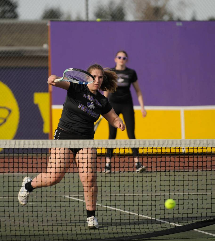 Sequim Gazette photo by Michael Dashiell / Sequims Sydney Hegtvedt, left, puts away a point as she and teammate Dani Herman take on Port Angeles Sarah Hancock and Cindy Liang in a No. 1 doubles match on March 29. The Sequim duo won in three sets – 6-3, 4-6, 6-3  as the Wolves swept their rivals at home, 7-0.