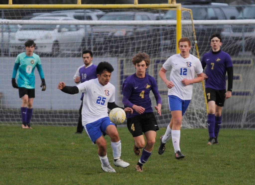 Sequim Gazette photo by Michael Dashiell / Sequims Lake Barrett (4) and Johnny Gaspar Raymundo (25) vie for the ball in the first half of a March 30 league game in Sequim.