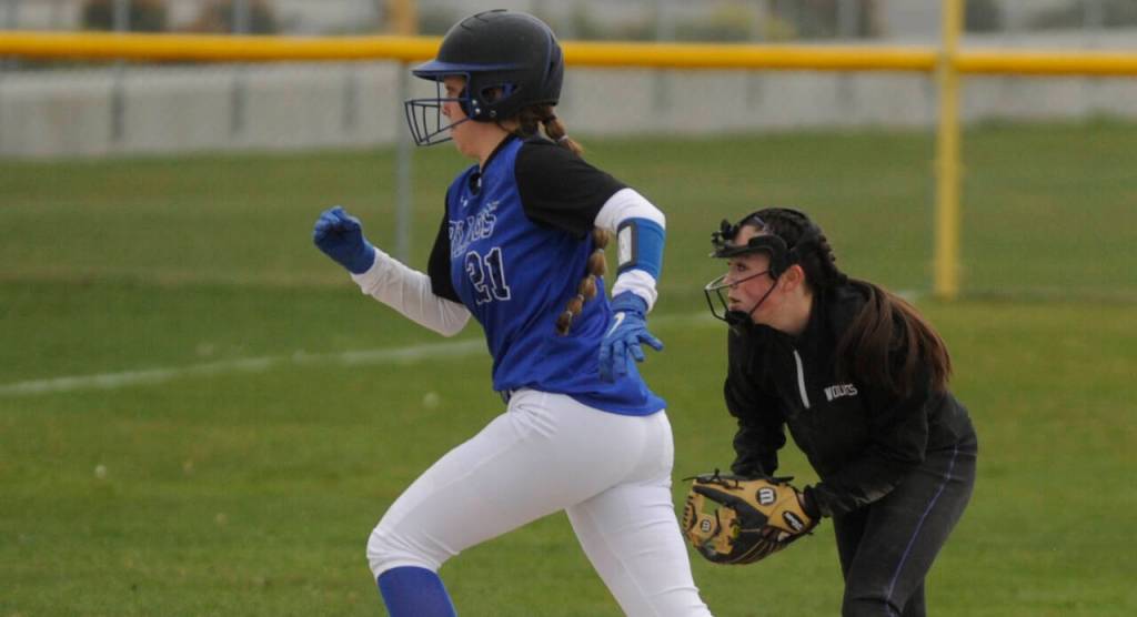 Sequim shortstop Hannah Bates, right, looks to make a force out as North Masons Adrianna Crowley races to third base in a March 30 Olympic League match-up. Sequim won, 10-8.