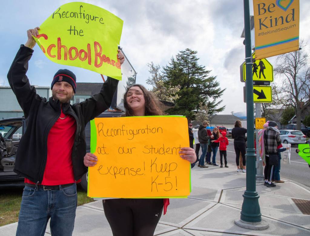 Sequim Gazette photo by Emily Matthiessen / Victor Orlando and Adrienne Kaestner on April 17 protest the reconfiguration of Sequims two elementary schools. We want Superintendent Regan Nickels to rescind decision, Kaestner said.  clearly dont have the support of the community and the parents  nor their trust. Orlando said, The only good that has come of this is weve made a lot of friends that we wouldnt have otherwise. If they dont have our best interest at heart, they should resign.