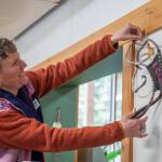 Sequim Gazette photo by Emily Matthiessen 
Artist Emily Carlquist adjusts one of her abstract pieces featuring weaving on a kelp root with poppies at Dandelion Botanical Company at 4681 Sequim-Dungeness Way, where Carlquist is the featured artist for the month of April.
