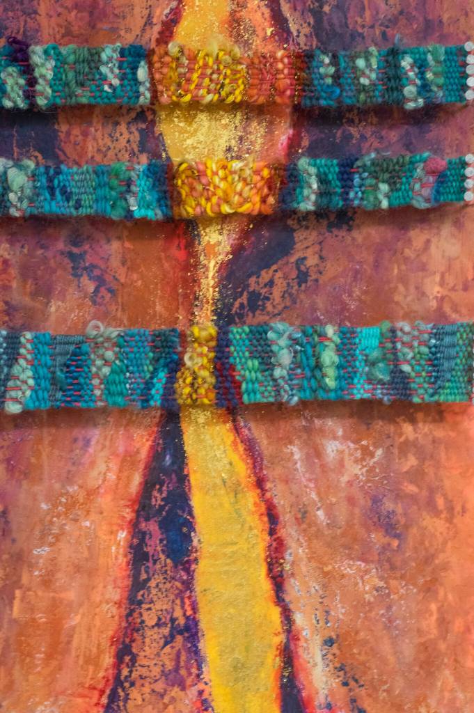 Sequim Gazette photo by Emily Matthiessen / A close-up of artist Emily Carlquists piece, Desert Walls, is evocative of the landscape of Southern Utah, where she grew up. This 15x30 piece is made from beeswax encaustic over textured acrylic overlapped by weavings made with wool roving and cotton yarn, explains the accompanying label.