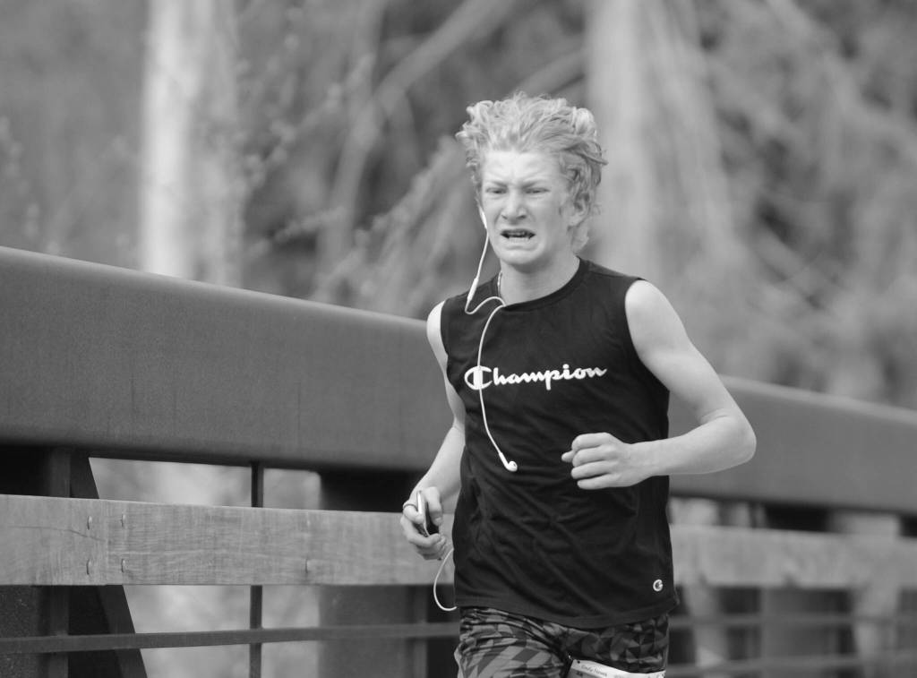 Sequim Gazette photo by Michael Dashiell / Connor Goff of Sequim grimaces as he nears the finish line at the Railroad Bridge Run 5k at Railroad Bridge Park on April 22. Goff finished in 19:51.