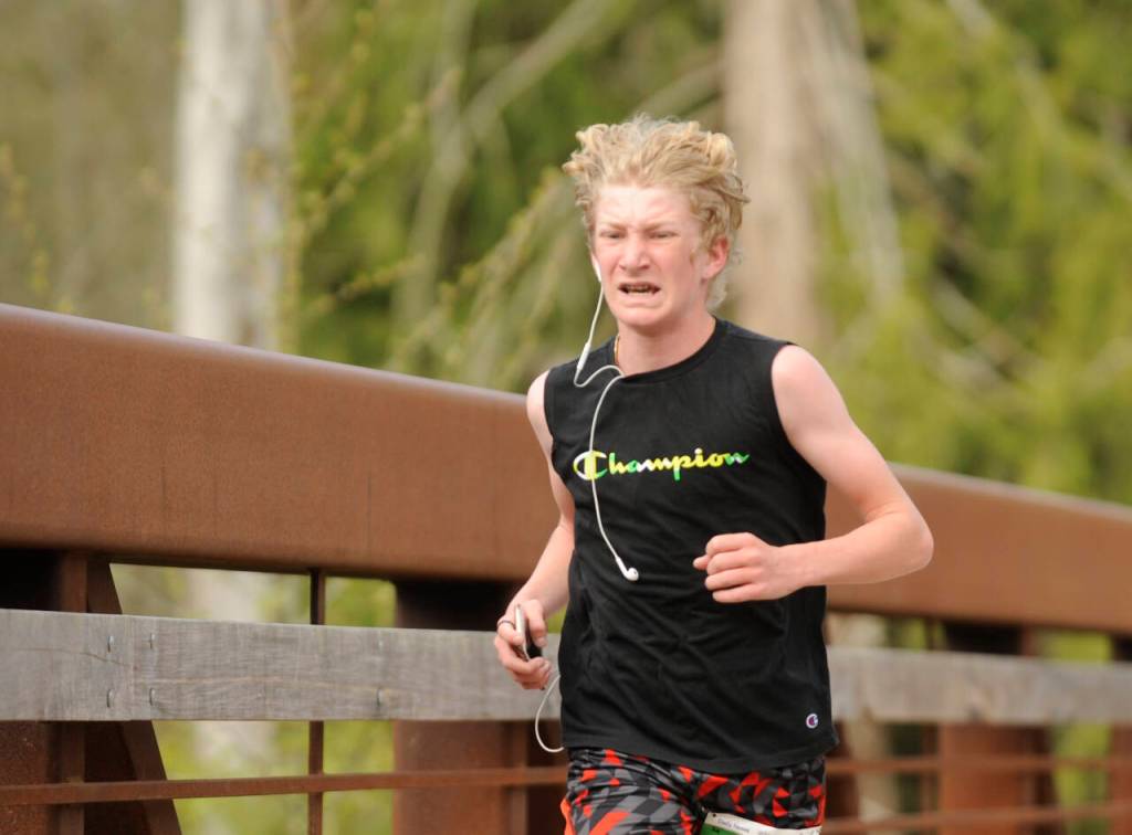 Sequim Gazette photo by Michael Dashiell / Connor Goff of Sequim grimaces as he nears the finish line at the Railroad Bridge Run 5k at Railroad Bridge Park on April 22. Goff finished in 19:51.