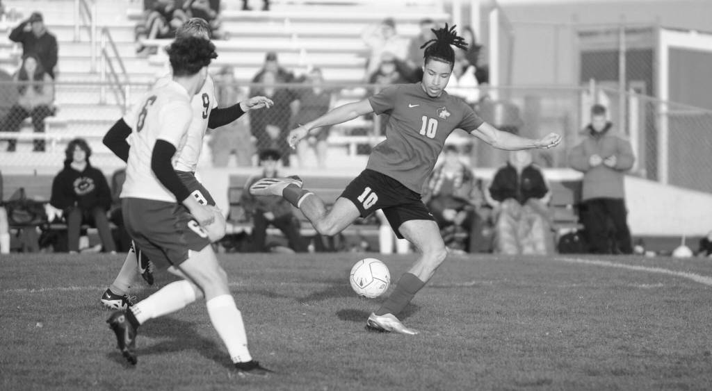 Sequim Gazette photo by Michael Dashiell / As Port Angeles Keane McClain (6) and David Hannes Spieker (9) look on, Sequims Mekhi Ashby looks for an open teammate in the first half of SHSs 1-0 win over the Roughriders on April 18.