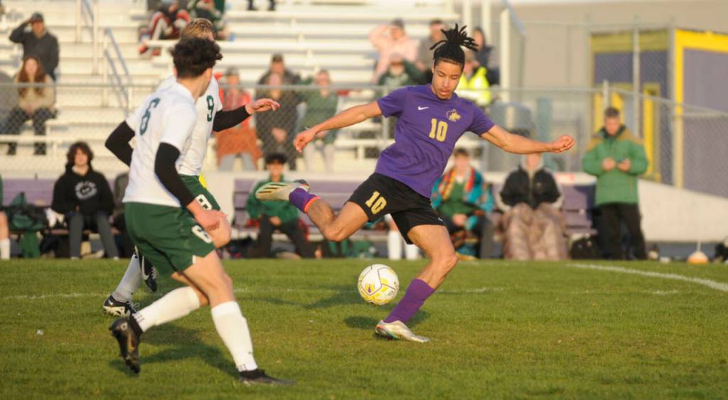 Sequim Gazette photo by Michael Dashiell / As Port Angeles Keane McClain (6) and David Hannes Spieker (9) look on, Sequims Mekhi Ashby looks for an open teammate in the first half of SHSs 1-0 win over the Roughriders on April 18.