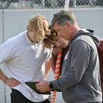 From left, Sequims Mirek and Ari Skov look over a video review of a vault with SHS coach Brad Moore at a practice last week.