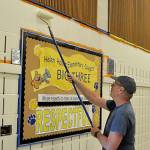 Tim Richards, lead pastor with Dungeness Community Church, helps paint a wall inside Helen Haller Elementarys cafeteria.