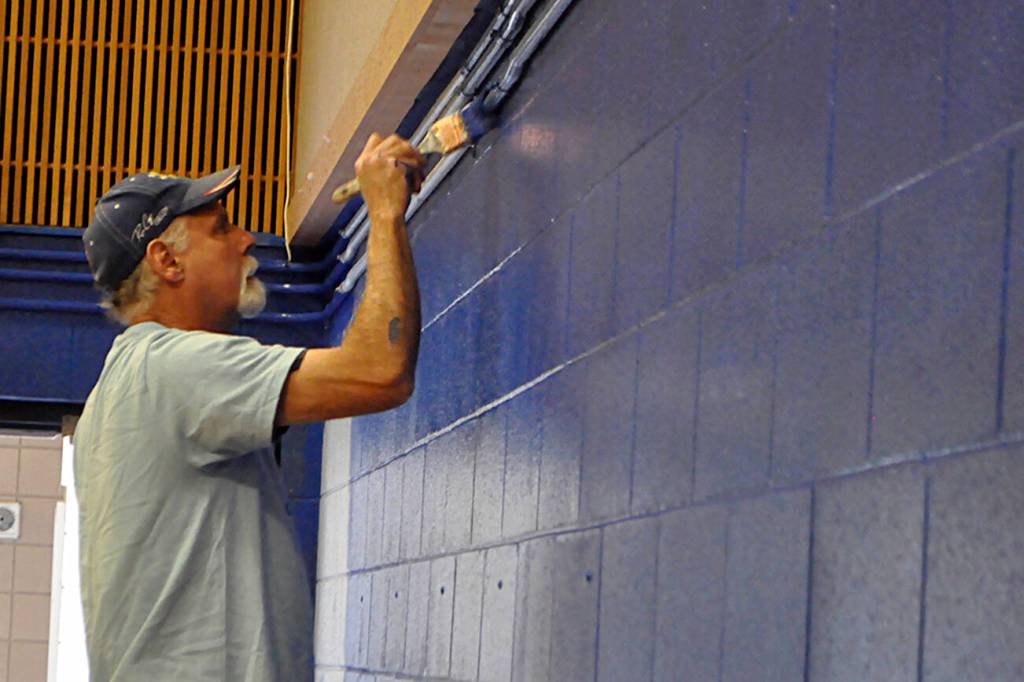 Sequim Gazette photo by Matthew Nash/ John Campbell with Dungeness Community Church paints a wall inside Helen Haller Elementarys cafeteria during Sequim Beautiful Day. It was his first time helping with the event, he said.