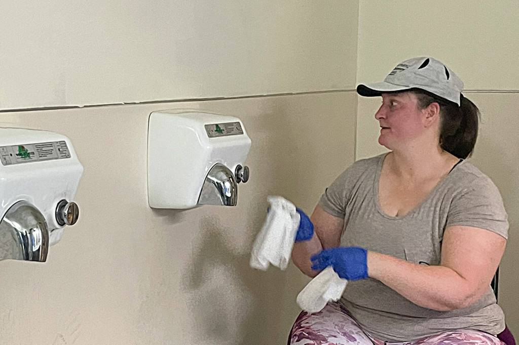 Sequim Gazette photo by Matthew Nash/ Rebecca Tenzythoff with Sequim Community Church, cleans walls after painting a bathroom at the Sequim Boys & Girls Club. She said it was her first time helping with the event and encourages locals to reach out to local organizations and schools to volunteer as they need help year-round.