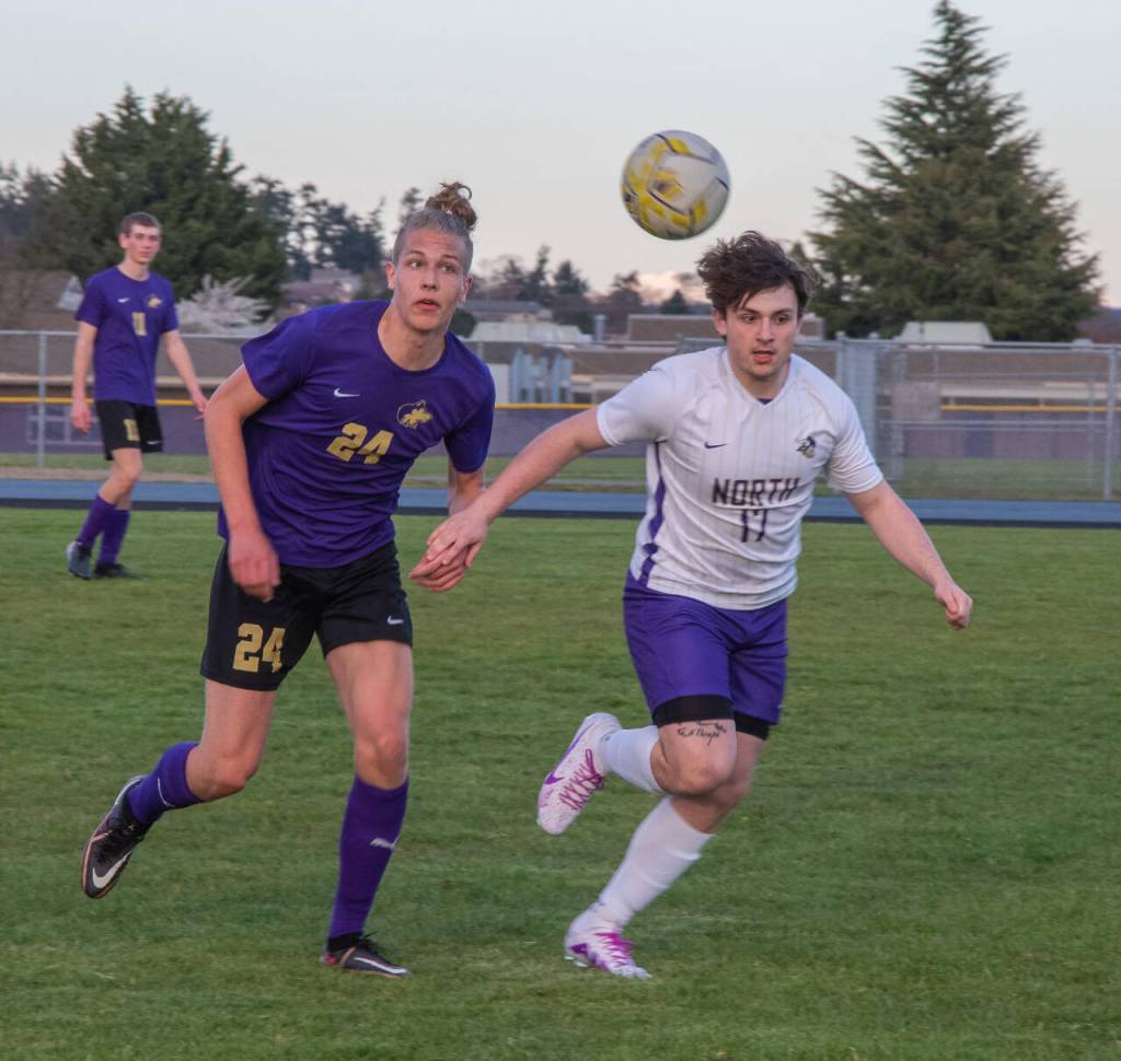 Sequim Gazette photo by EmilyMatthiessen / Sequims Jack Henninger, left and North Kitsaps Trevor Flowers look to gain possession in an April 24 Olympic League game in Sequim. Flowers Vikings topped the Wolves, 2-0.