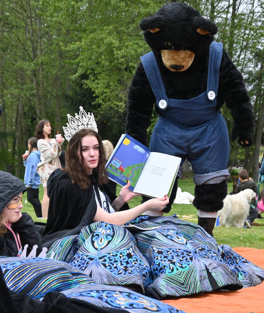 Sequim Gazette photo by Michael Dashiell / With help from the Black Bear Diner bear, Sequim Irrigation Festival queen Pepper Reymond shares stories with youngsters at the Family Fun Day event on May 6.