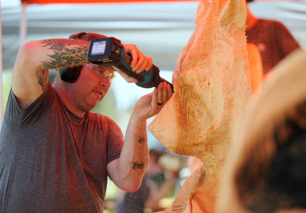 Nick Bielby of the Port Angeles-based Nicklby Wood Carving, works on a large bear sculpture at the Sequim Irrigation Festival Logging Show on Friday. Festival activities continue Saturday. (Michael Dashiell/Olympic Peninsula News Group )