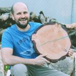 Photo courtesy of Sequim Farmers & Artisans Market 
Jack Just holds a customized wood round table top outside his workshop.