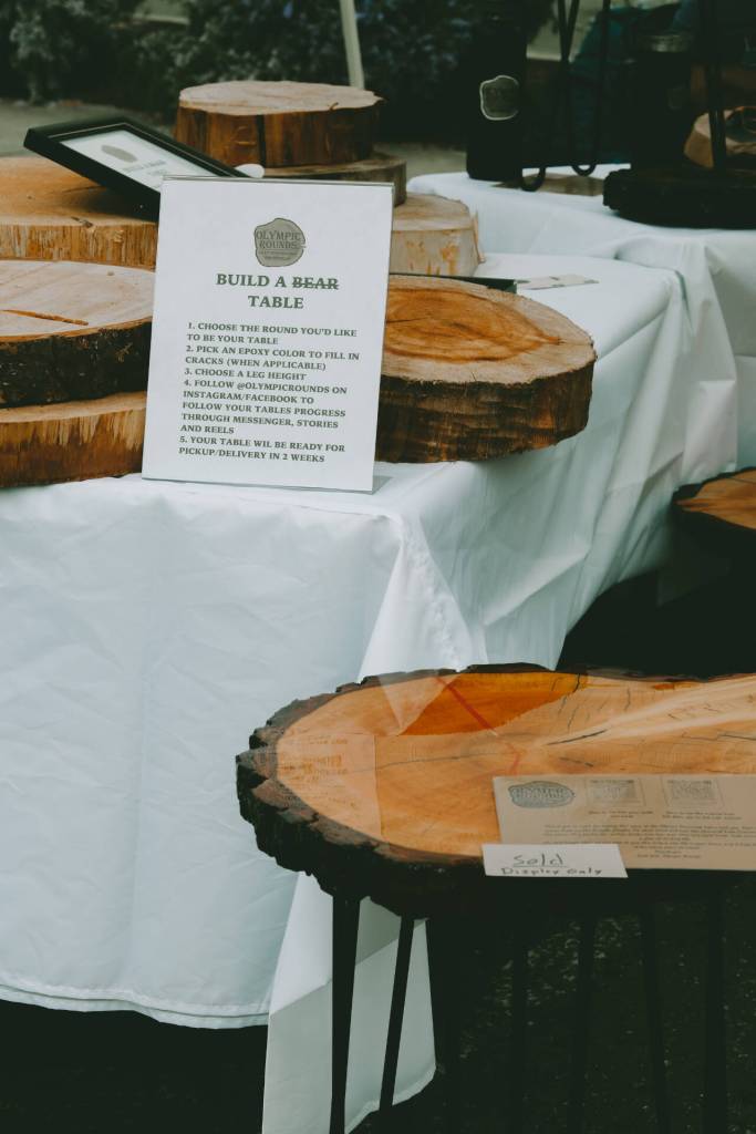 Photo courtesy of Sequim Farmers & Artisans Market / The Build a Table display is pictured at the Olympic Rounds booth at the Sequim Farmers & Artisans Market. Here, customers can order and customize a unique local wood table on Market Saturdays.