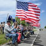 Sequim Gazette photo by Michael Dashiell / Local veterans and military groups offer the stars and stripes at Olympic Peninsula Academys new flagpole project last week.