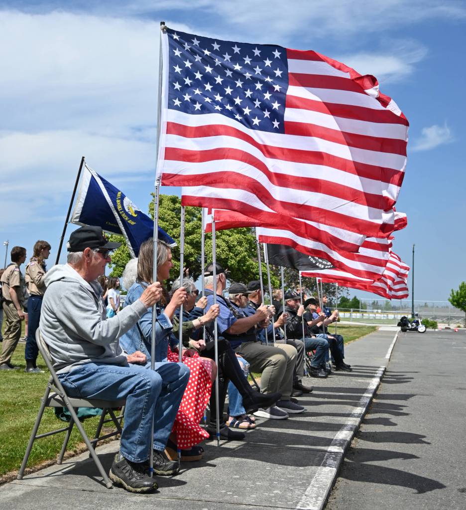 Sequim Gazette photo by Michael Dashiell / Local veterans and military groups offer the stars and stripes at Olympic Peninsula Academys new flagpole project last week.